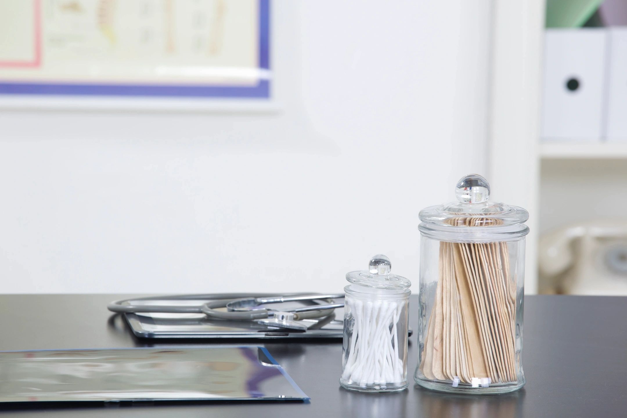 stethoscope, cotton swabs and tongue depressors sitting on a desk