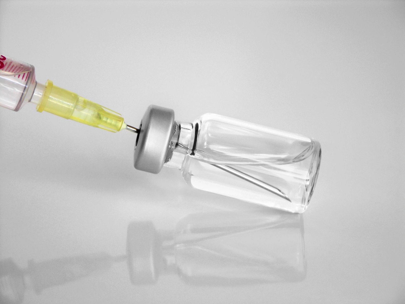 needle inserted into vaccine vial