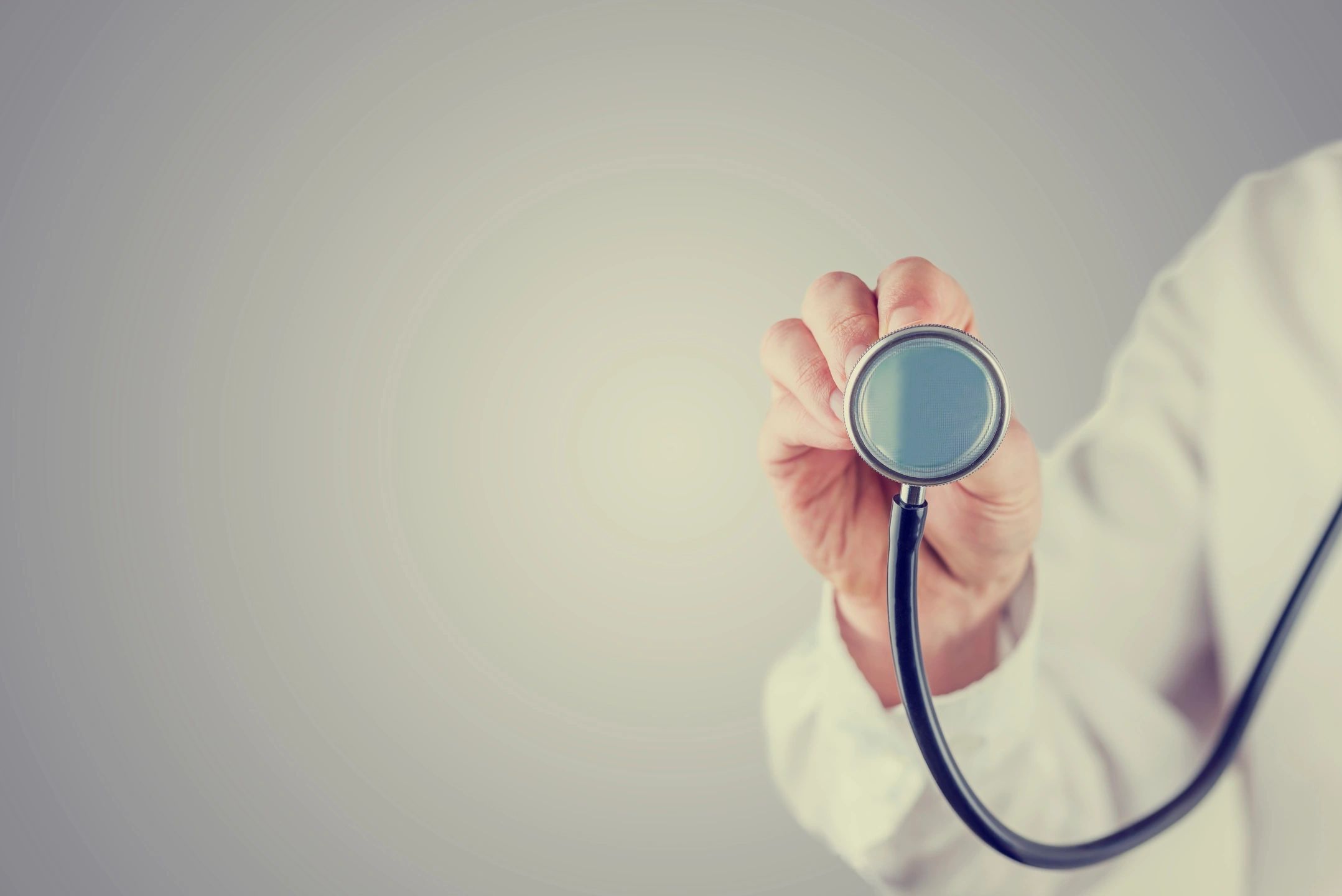 stethoscope held up by doctor in white coat
