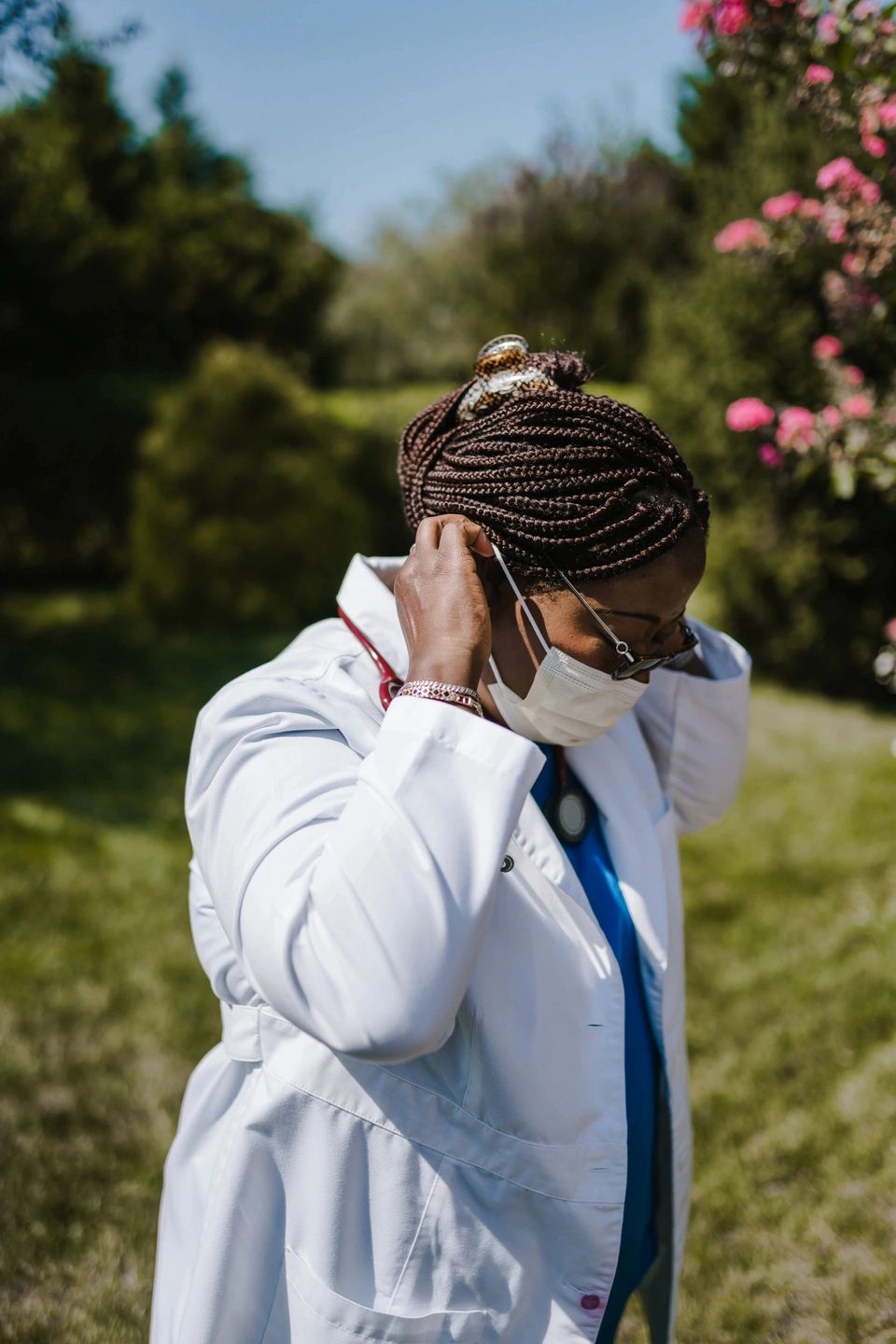 doctor in white coat putting on a facemask